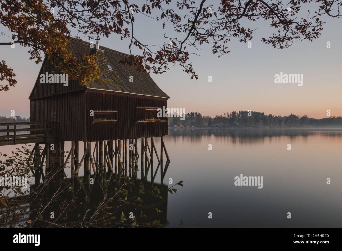Vecchia casa di pesca all'alba su un lago in Germania. Foto Stock