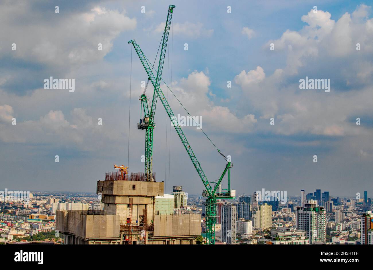 Gru da cantiere o gru da arrampicata su un tetto di un alto progetto da completare Foto Stock