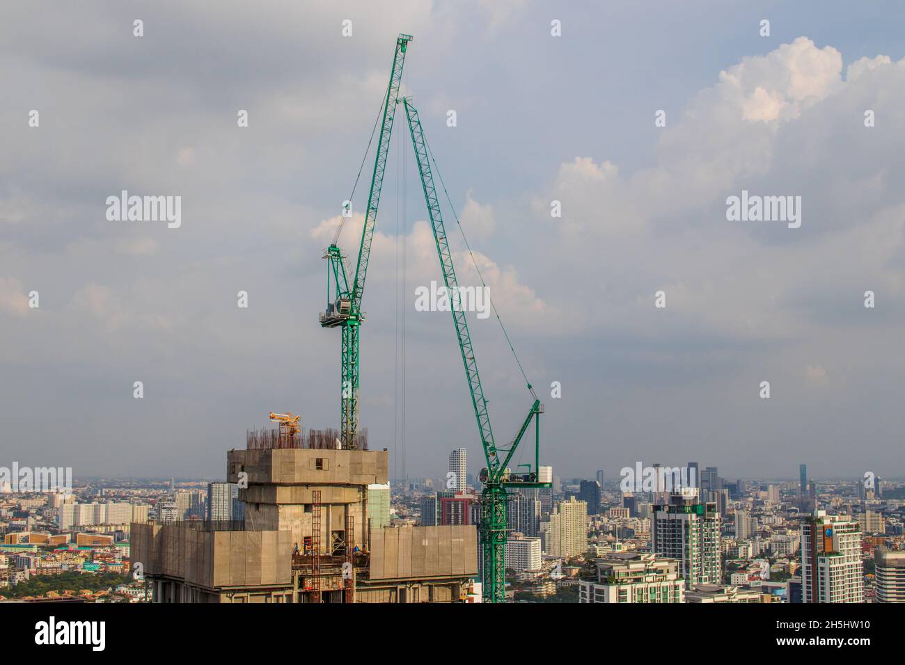 Gru da cantiere o gru da arrampicata su un tetto di un alto progetto da completare Foto Stock