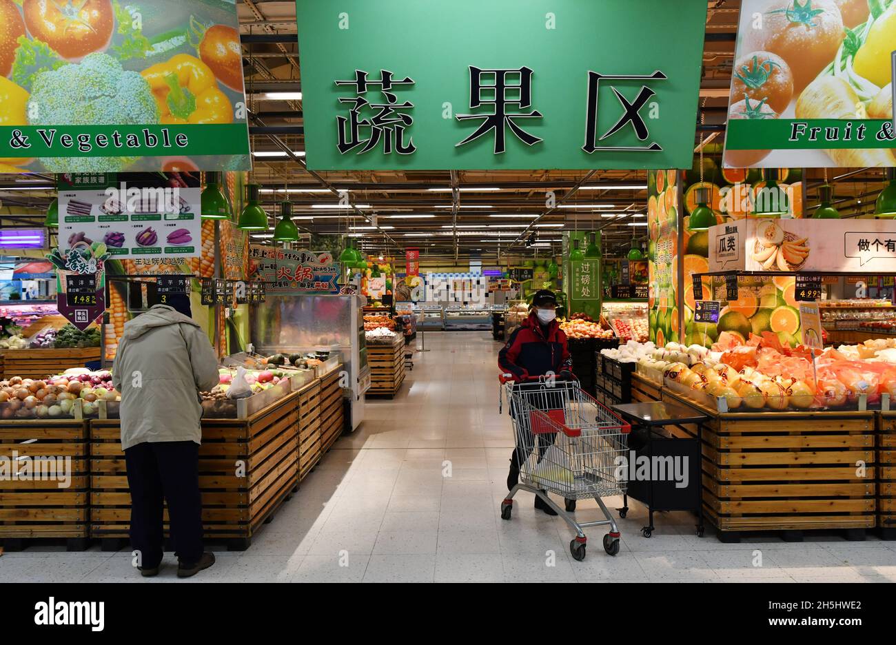 Harbin, la provincia cinese di Heilongjiang. 10 novembre 2021. Un cittadino acquista frutta in un supermercato ad Harbin, provincia Heilongjiang della Cina nord-orientale, 10 novembre 2021. Di fronte alle recenti temperature fredde e alle tempeste di neve, le autorità locali hanno avviato un programma di emergenza per garantire l'approvvigionamento locale di energia, gas e calore, garantendo la normale vita delle persone. Credit: Wang Jianwei/Xinhua/Alamy Live News Foto Stock