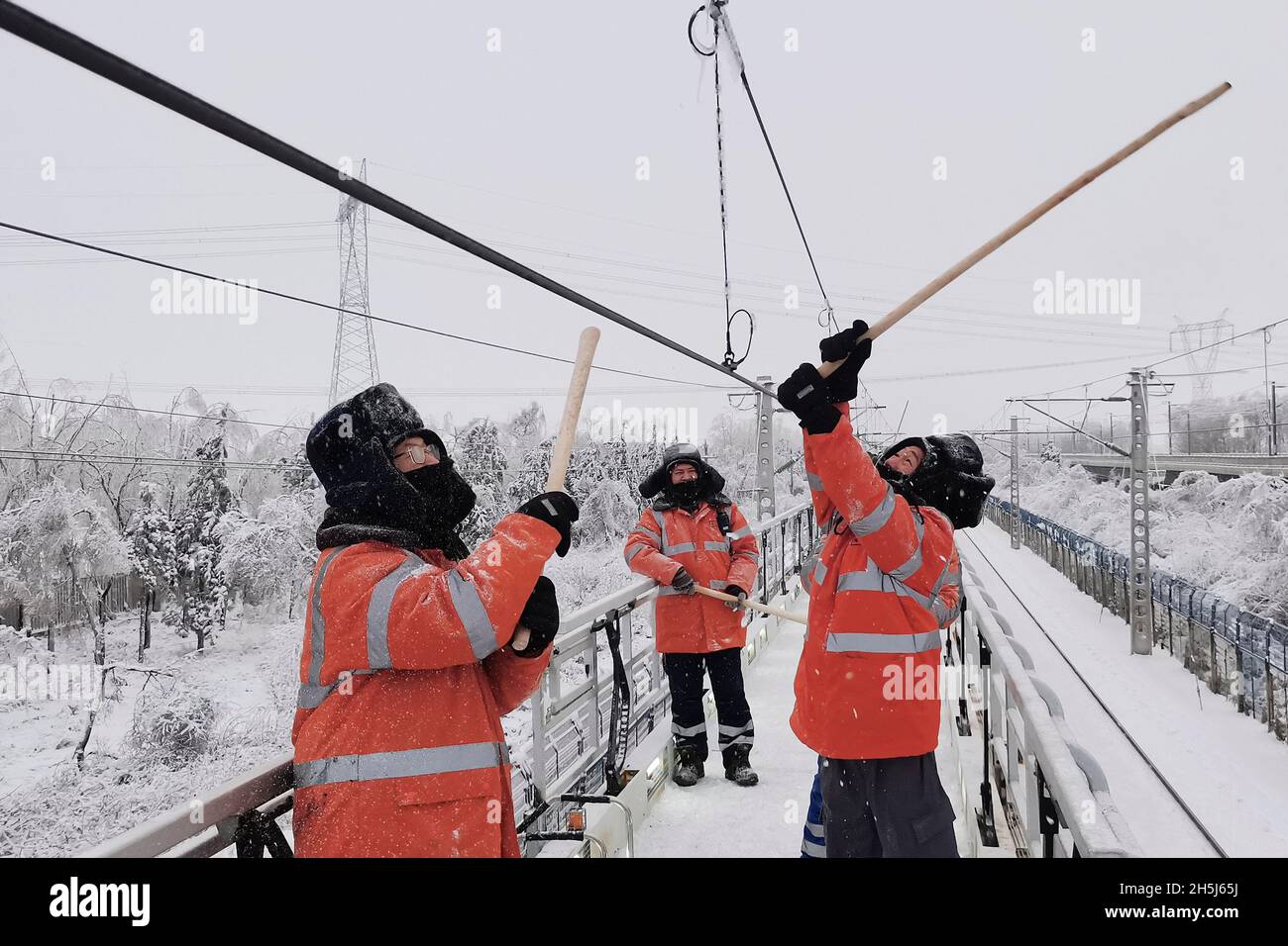 Harbin. 10 novembre 2021. Lavoratori della China Railway Harbin Bureau Group chiaro ghiaccio a Harbin, provincia di Heilongjiang della Cina nord-orientale, 10 novembre 2021. Di fronte alle recenti tempeste di neve e di freddo, le autorità locali di Harbin hanno lanciato un programma di risposta alle emergenze per garantire l'approvvigionamento di energia, gas e calore, garantendo la normale vita delle persone. Credit: Xinhua/Alamy Live News Foto Stock