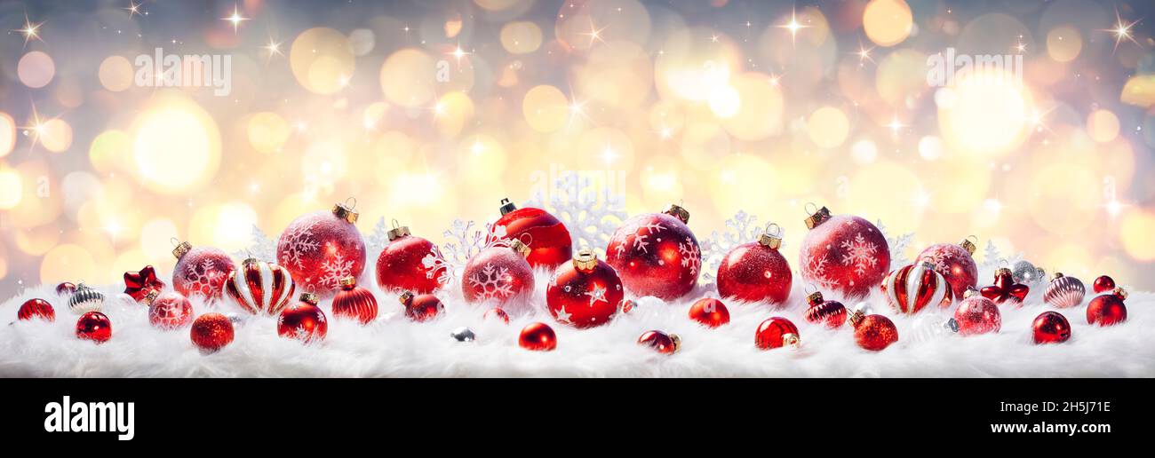 Palline rosse di Natale con luci dorate su pelliccia bianca - carta defocused dell'astratto Foto Stock
