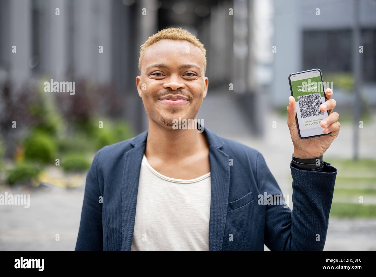 Uomo show telefono con l'app di vaccinazione di Coronavirus Foto Stock