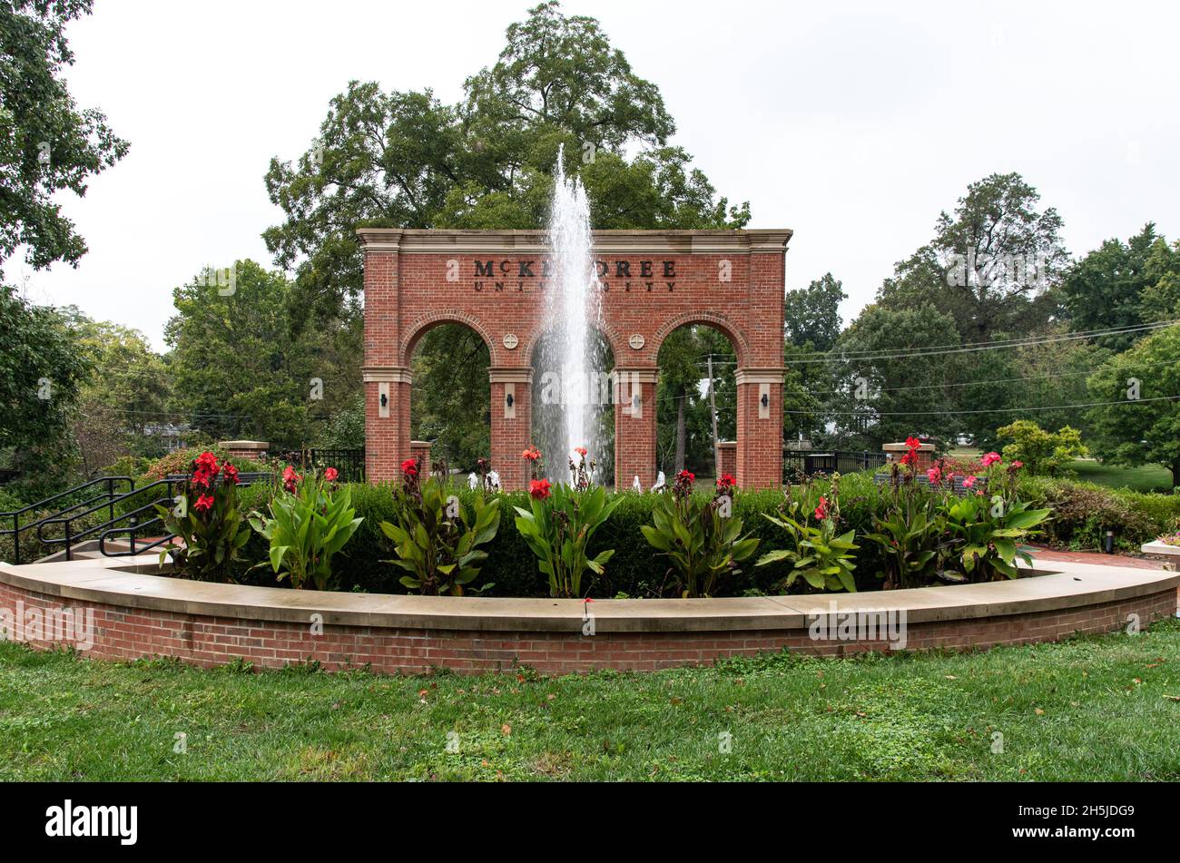 Ingresso alla McKendree University con ingresso in mattoni monumento con tre archi nel patio circolare, una fontana, vegetazione, Lebanon, Illinois, USA. Foto Stock