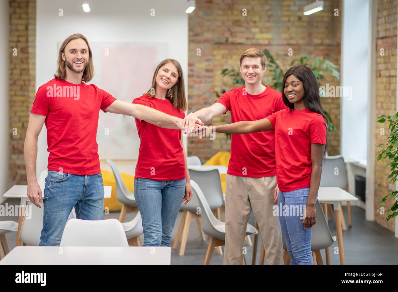 Squadra di giovani volontari in maglietta rossa Foto Stock