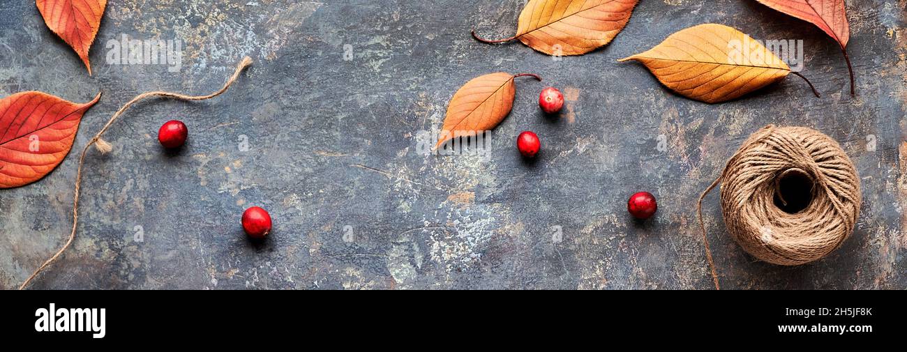 Decorazioni autunnali fai da te con materiali naturali. Fare ghirlanda con corda di canapa e foglie d'autunno. Foto Stock