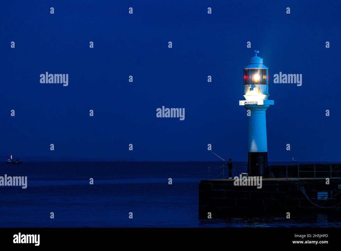 Pesca da ragazzi dal molo all'ingresso del porto di Penzance. Foto Stock