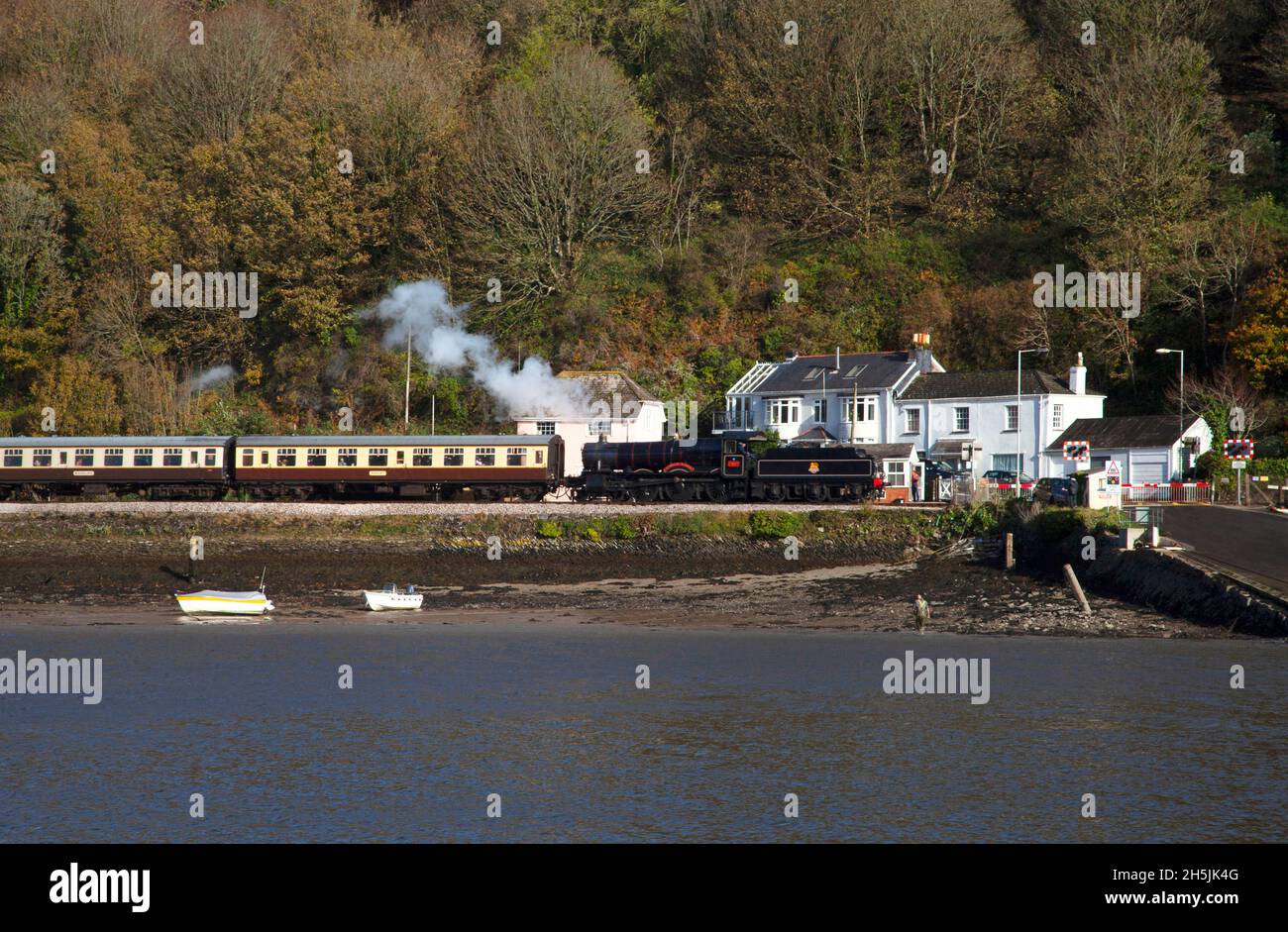 Dartmouth treno a vapore treno motore locomotiva carrozze autunno caduta lascia livello attraversando fiume Dart Devon copia spazio barche pescatore Foto Stock