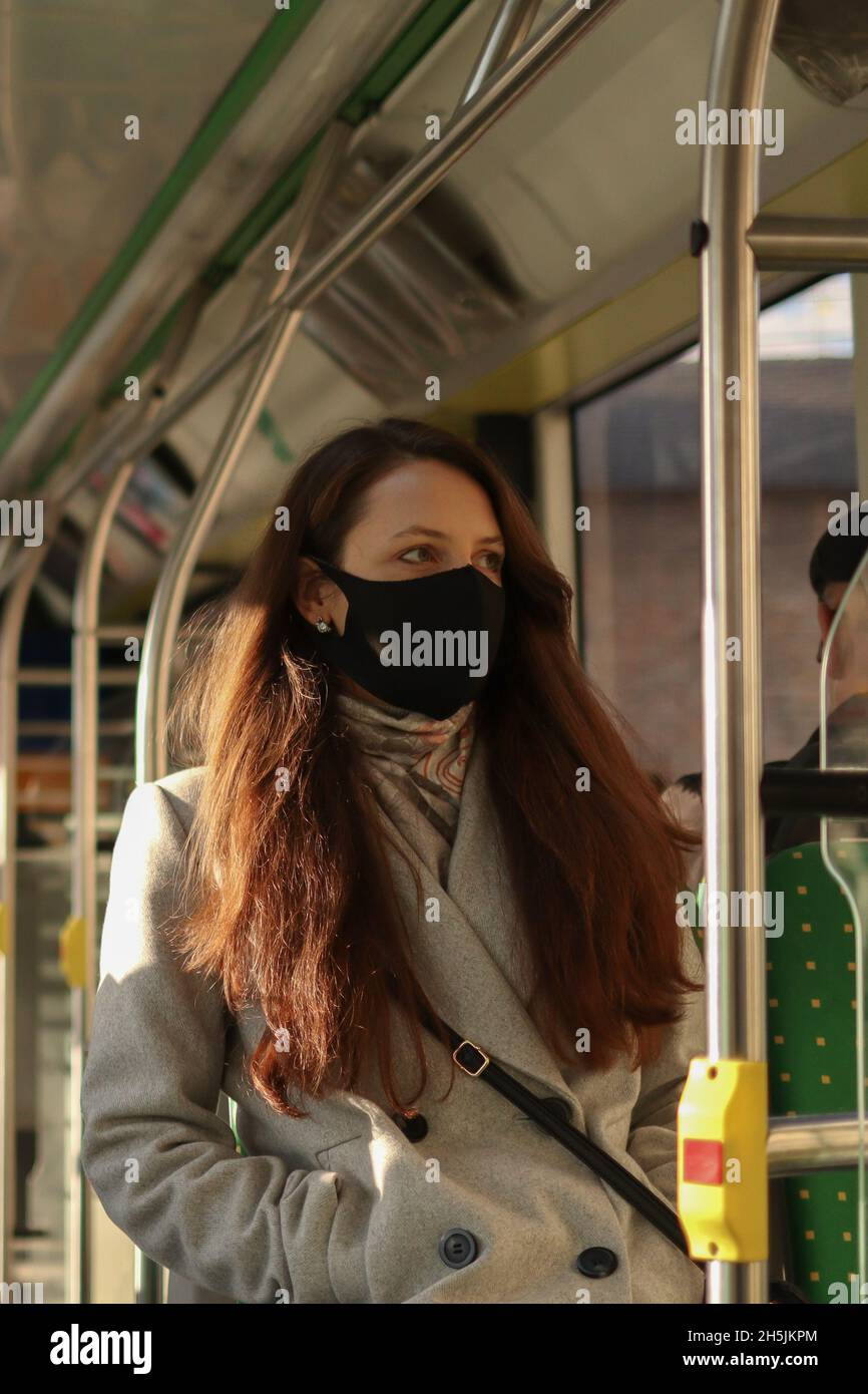 Giovane donna in maschera di viso è in viaggio in autobus. Precauzioni nei trasporti pubblici Foto Stock