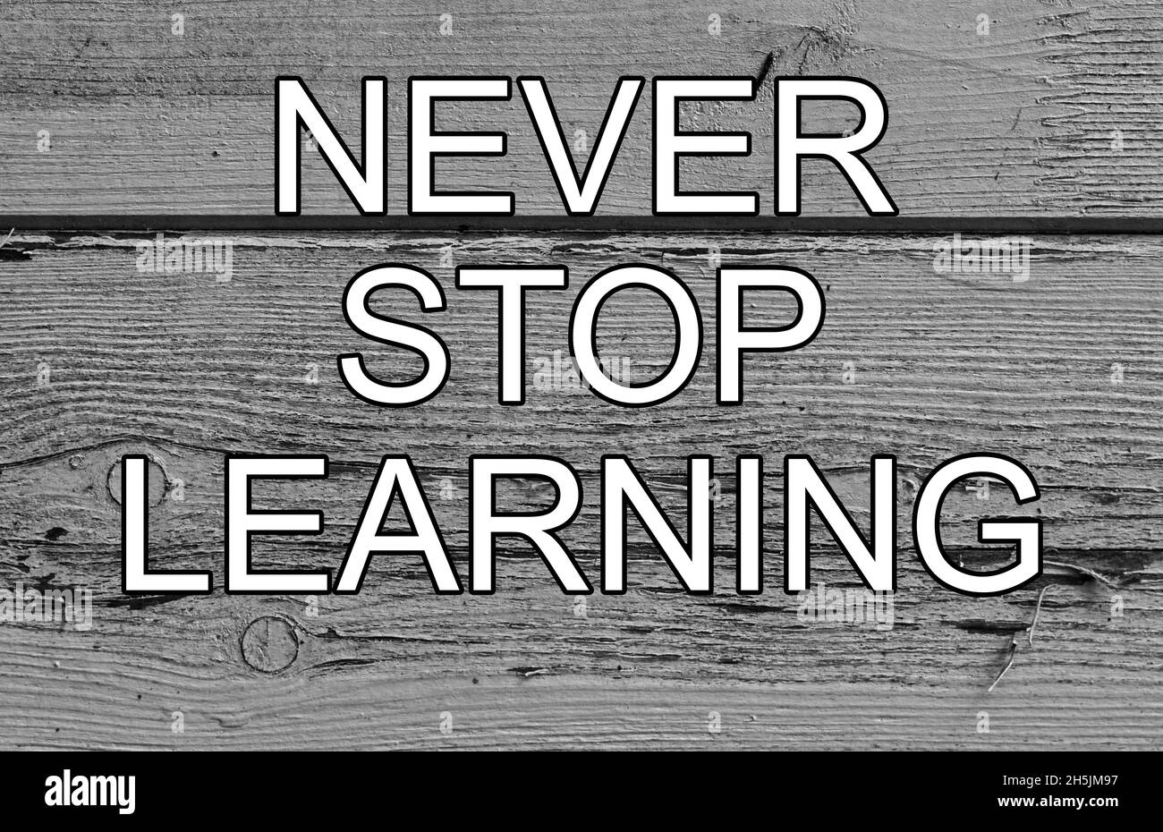 non smettere mai di imparare le lettere bianche di legno sfondo Foto Stock