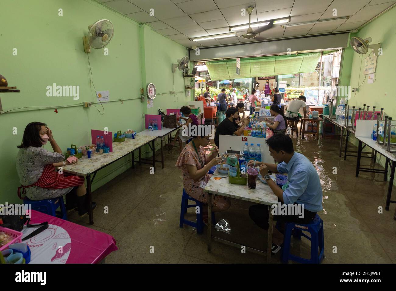 La gente è vista mangiare da un ristorante sommerso in Wang Lang Market.Chao Phraya fiume è traboccante influenzato da pioggia pesante che causa l'inondazione nel mercato di Wang Lang e molte zone basse giacenti lungo il fiume Chao Phraya. (Foto di Phobthum Yingpaiboonsuk / SOPA Images/Sipa USA) Foto Stock