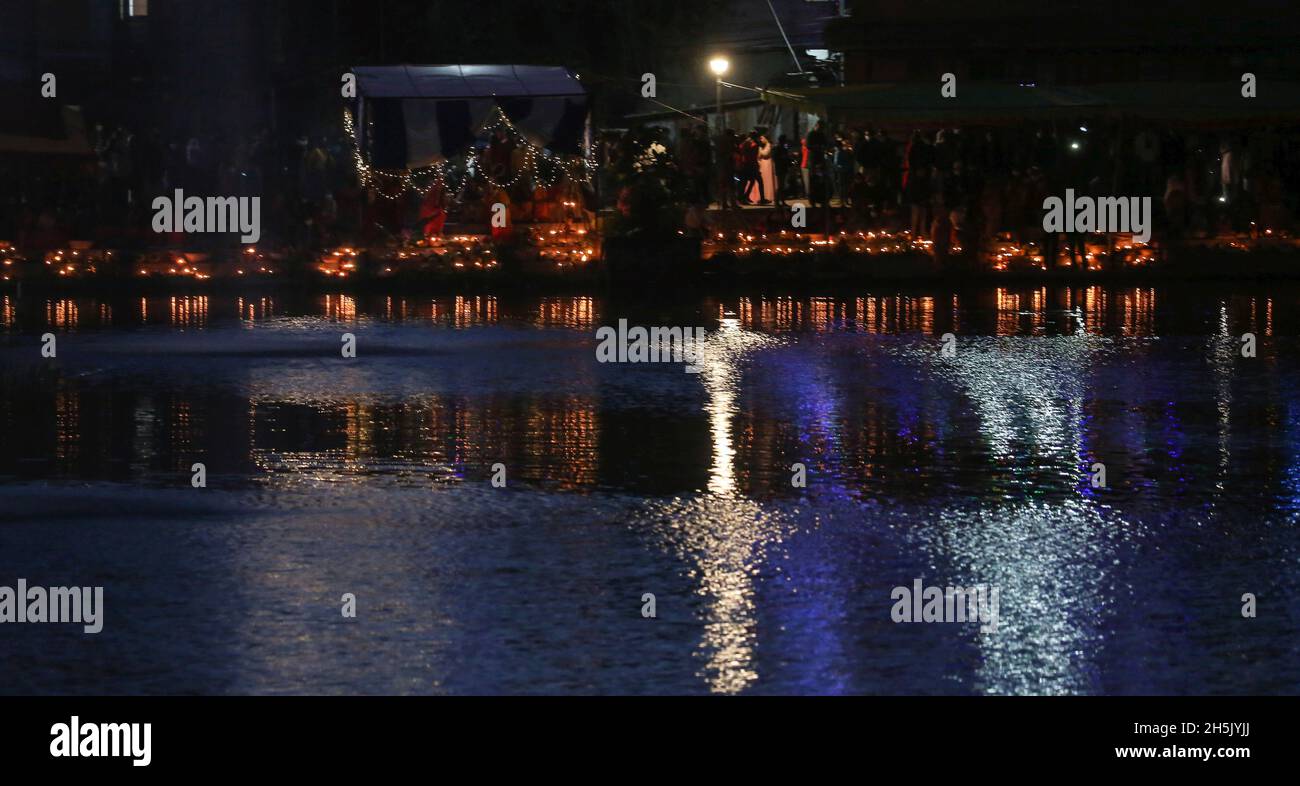 Kathmandu, Bagmati, Nepal. 10 novembre 2021. Lo stagno di Kamal Pokhari è illuminato con le luci mentre la gente offre le preghiere durante il festival di Chhath a Kathmandu, Nepal, il 10 novembre 2021. La festa di Chhath è dedicata al sole, che è considerato un segno di stabilità e prosperità, e una dea vedica ''Chhathi Maiya. (Credit Image: © Sunil Sharma/ZUMA Press Wire) Foto Stock