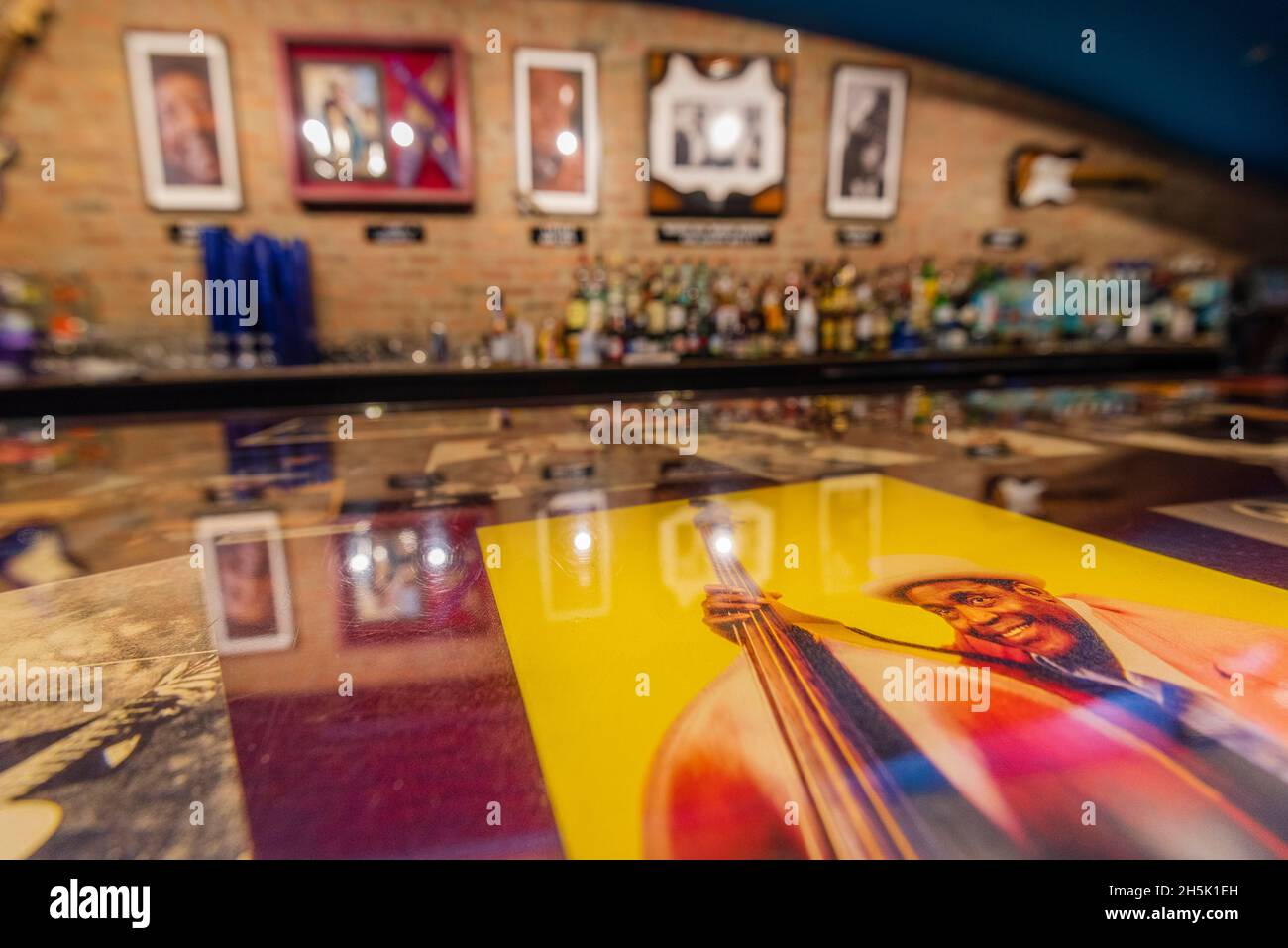 Esposizione di opere d'arte dei musicisti Blues lungo un bar con bottiglie di alcool in un Blues Club; Chicago, Illinois, Stati Uniti d'America Foto Stock