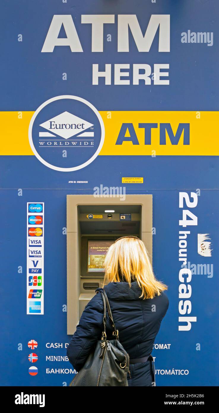 Donna che preleva denaro da un bancomat a Cordoba, provincia di Cordoba, Andalusia, Spagna. ATM, Automated Teller Machine, a volte chiamato Hol Foto Stock