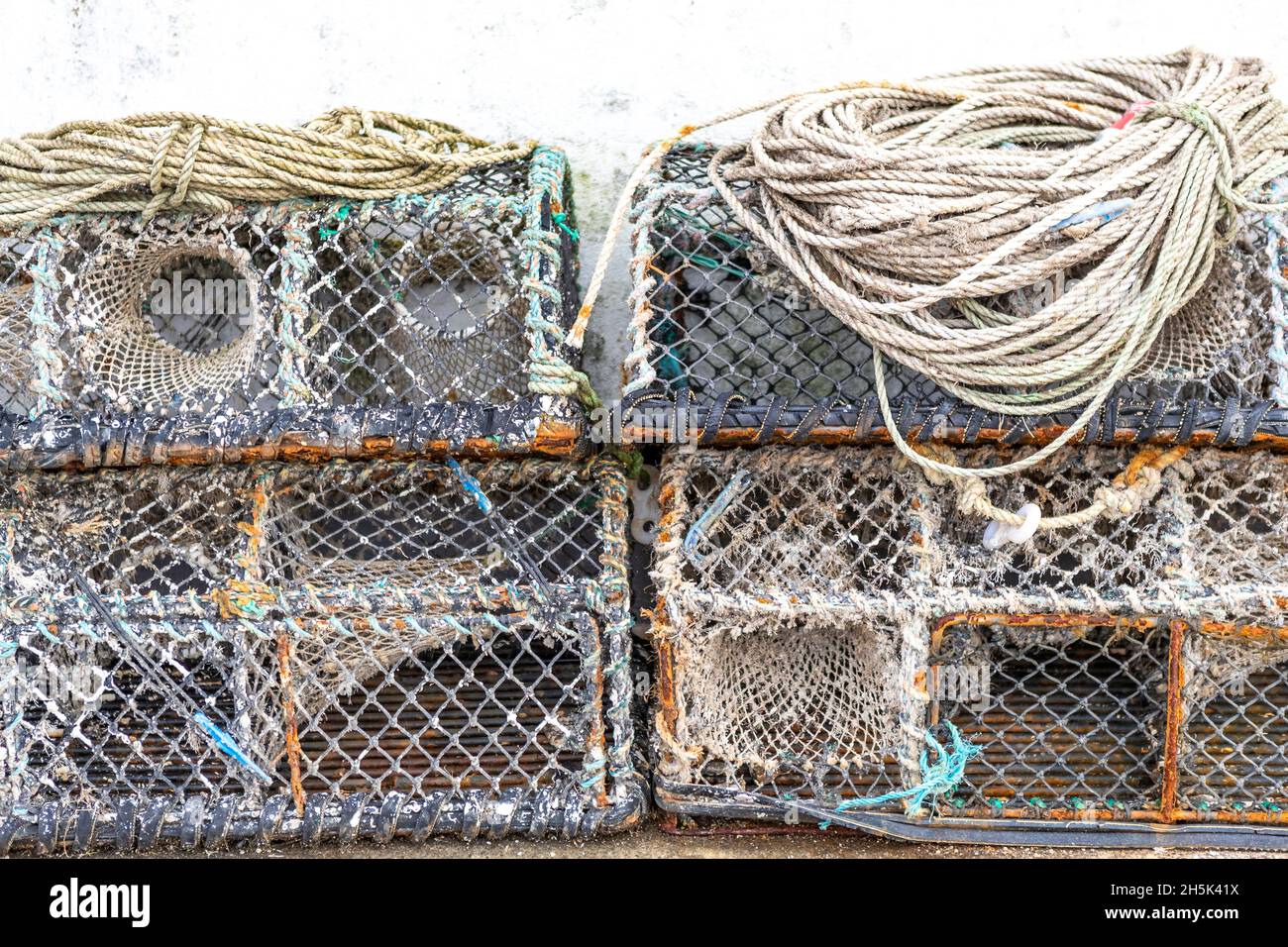 Vasi di aragosta impilati fuori di una casa di pesce, Newlyn Harbour, Cornovaglia. REGNO UNITO Foto Stock