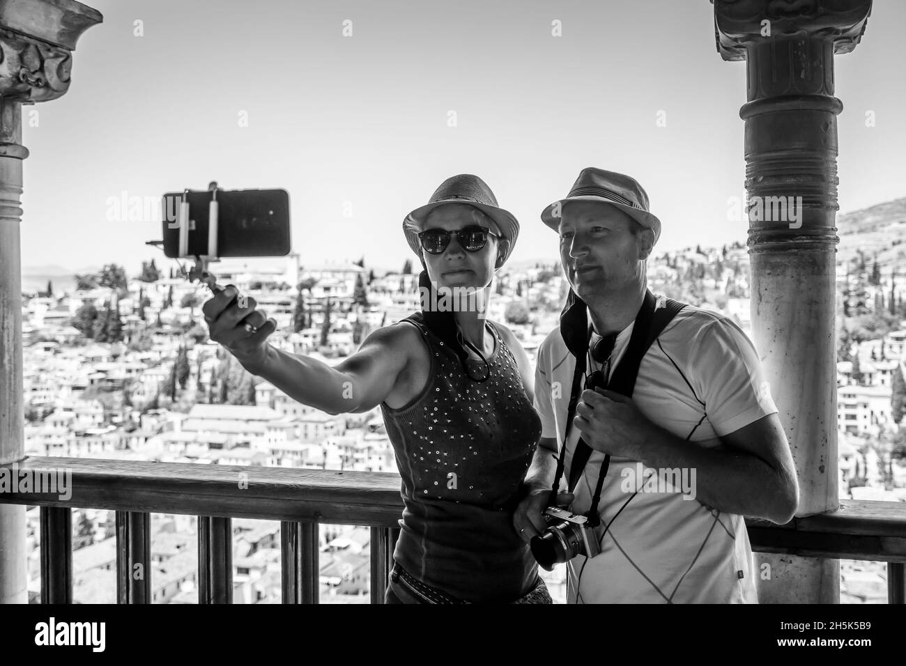 Una coppia turistica che prende selfie nel palazzo dell'Alhambra con la vista di Granada, Andalusia, Spagna Foto Stock