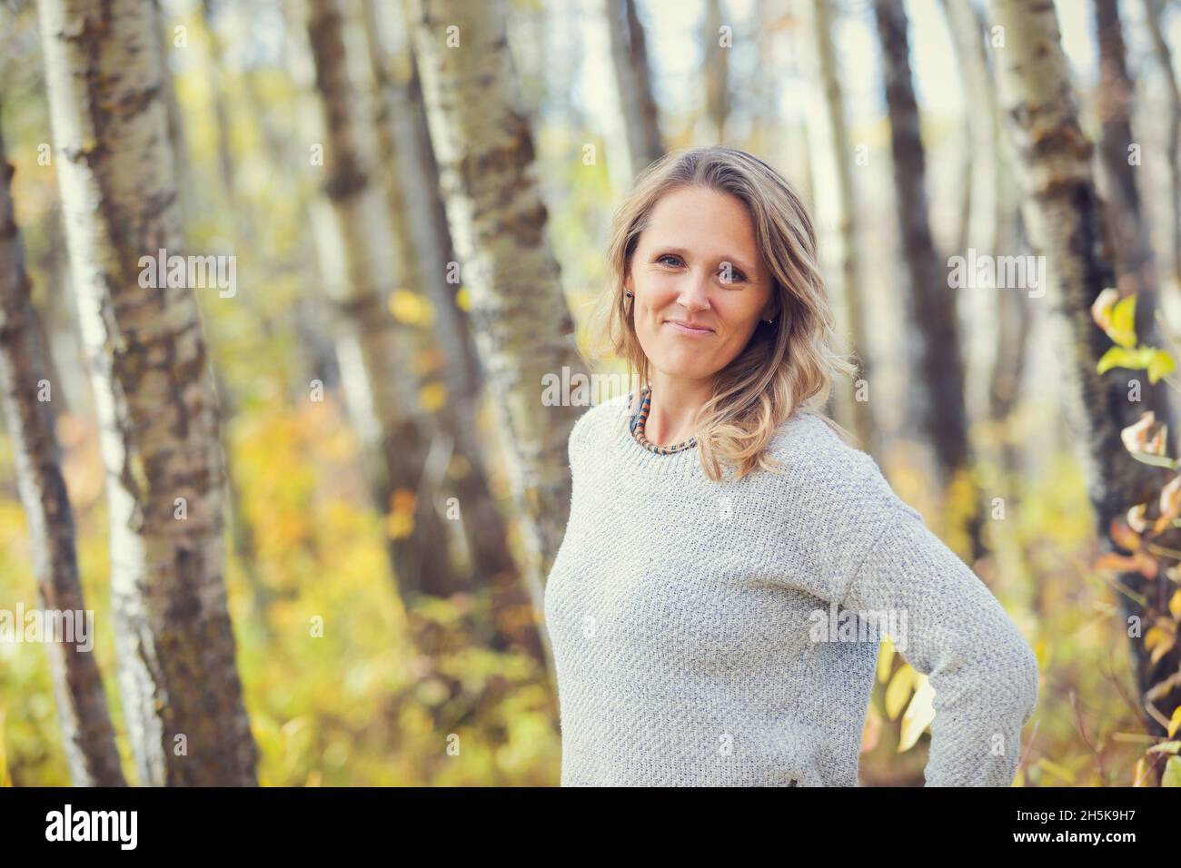 Un ritratto di una bella donna matura in un parco cittadino in un caldo pomeriggio autunnale; St. Albert, Alberta, Canada Foto Stock