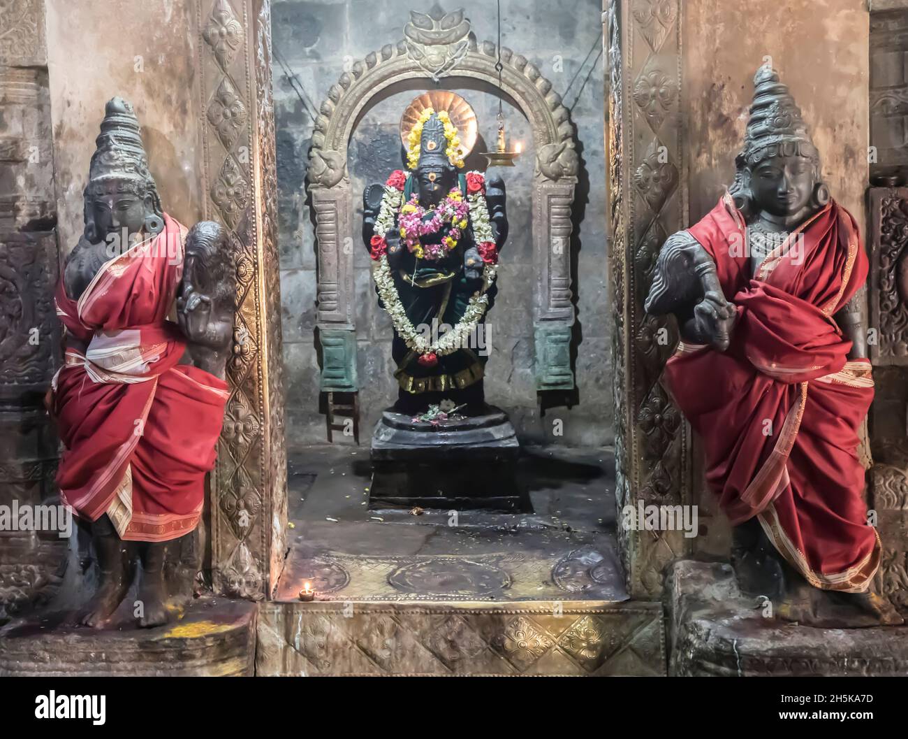 Alcova con statua della divinità indù in parete con statue guardiane avvolte in seta su entrambi i lati al Tempio di Airavatesvara dell'era Dravidiana di Chola Foto Stock