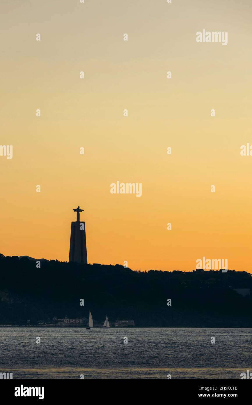 Santuario di Cristo Re, con un cielo dorato luminoso al tramonto; Lisbona, Portogallo Foto Stock