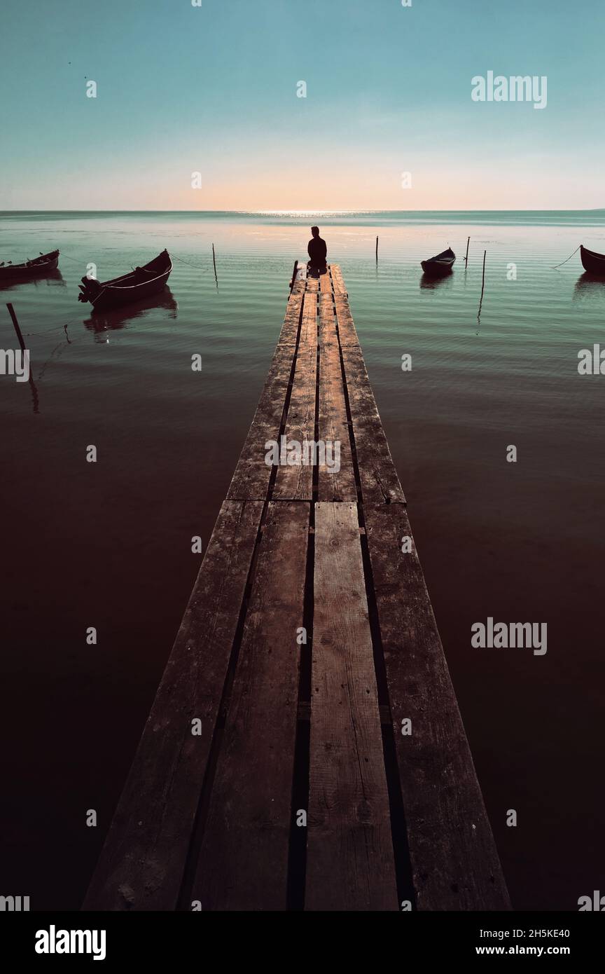 Astratto giovane uomo tempo che passa su Pontoon in legno Foto Stock