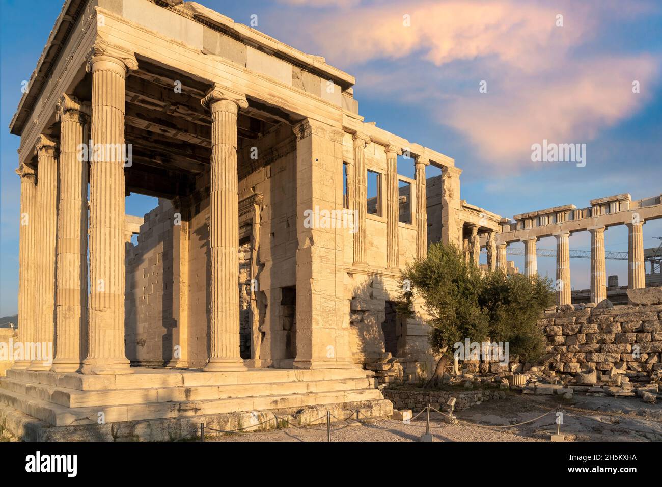 Erechtheion Tempio (Erechtheum) con i Cariatidi presso il sito archeologico dell'Acropoli di Atene, Grecia. Tempio del Partenone sullo sfondo Foto Stock