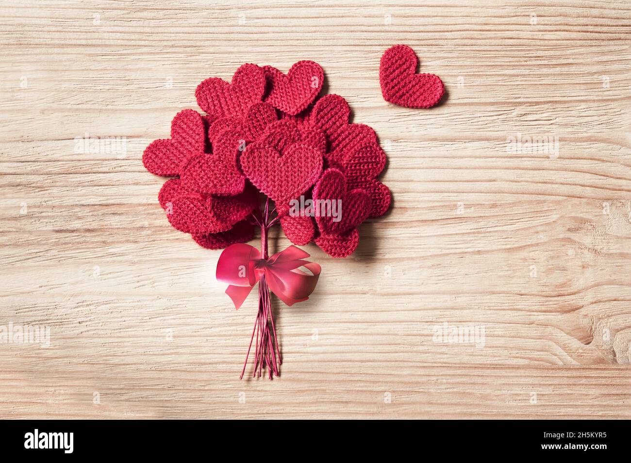 Cuori d'amore lavorati a maglia su uno sfondo di legno, giorno di valentine postino concetto di scheda Foto Stock