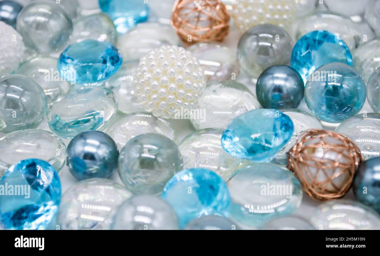 Bellissimo sfondo di perle di vetro blu chiaro, trasparenti e perle bianche. Spazio di copia. Foto Stock