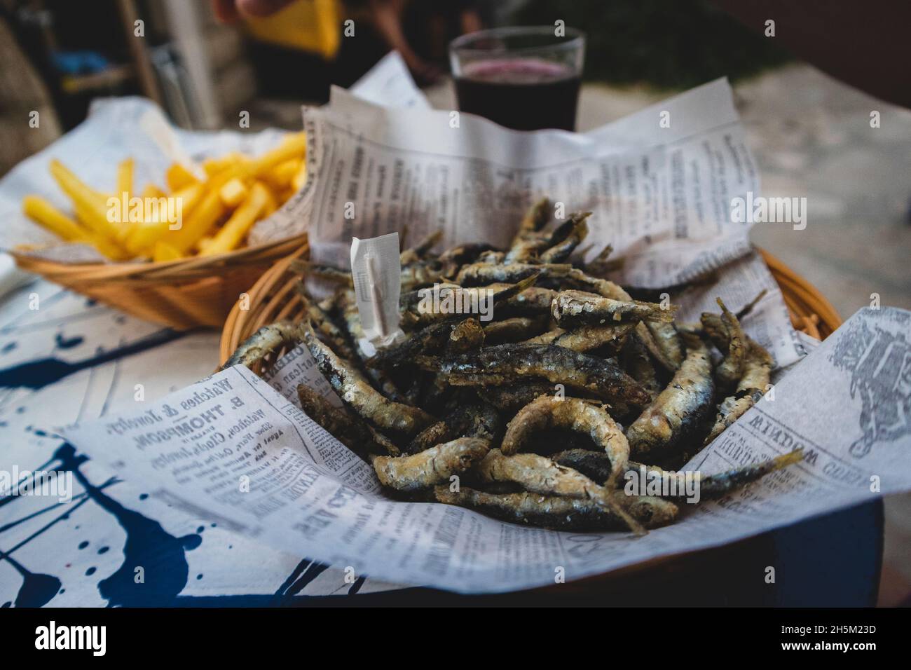 Pesce blu fritto con patatine fritte servito sul tavolo nella città di Primosten, Croazia, popolare destinazione turistica Foto Stock