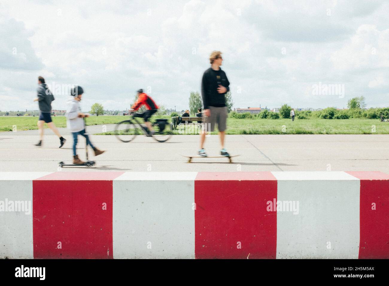 Berlino, Tempelhof, 15.05.21: Familie mit Vater und Sohn fahren mit Skateboard und Roller (Scooter) ihre Runden auf dem stillgelegten Flughafen. Foto Stock