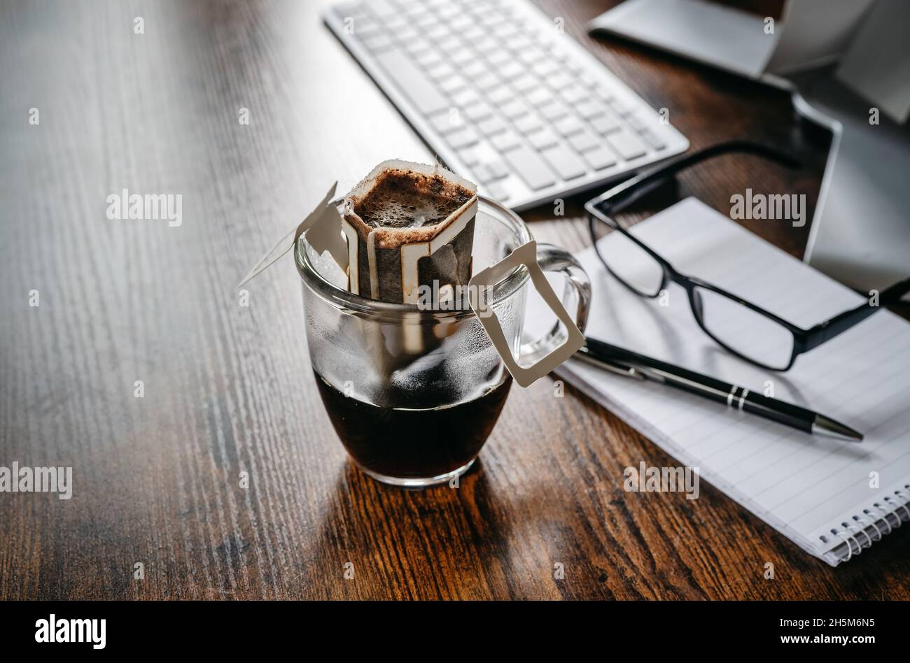 Tazza di delizioso caffè appena fatto sul tavolo da ufficio Foto Stock