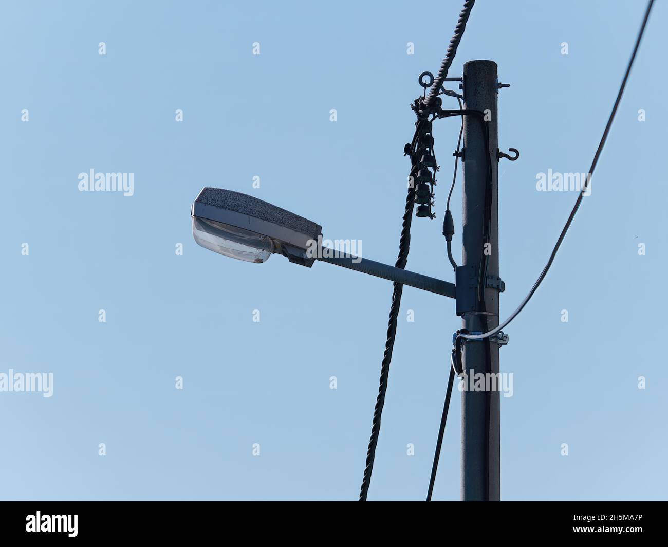 Luci per la circolazione su strada attaccate a un palo contro un cielo blu durante il giorno Foto Stock