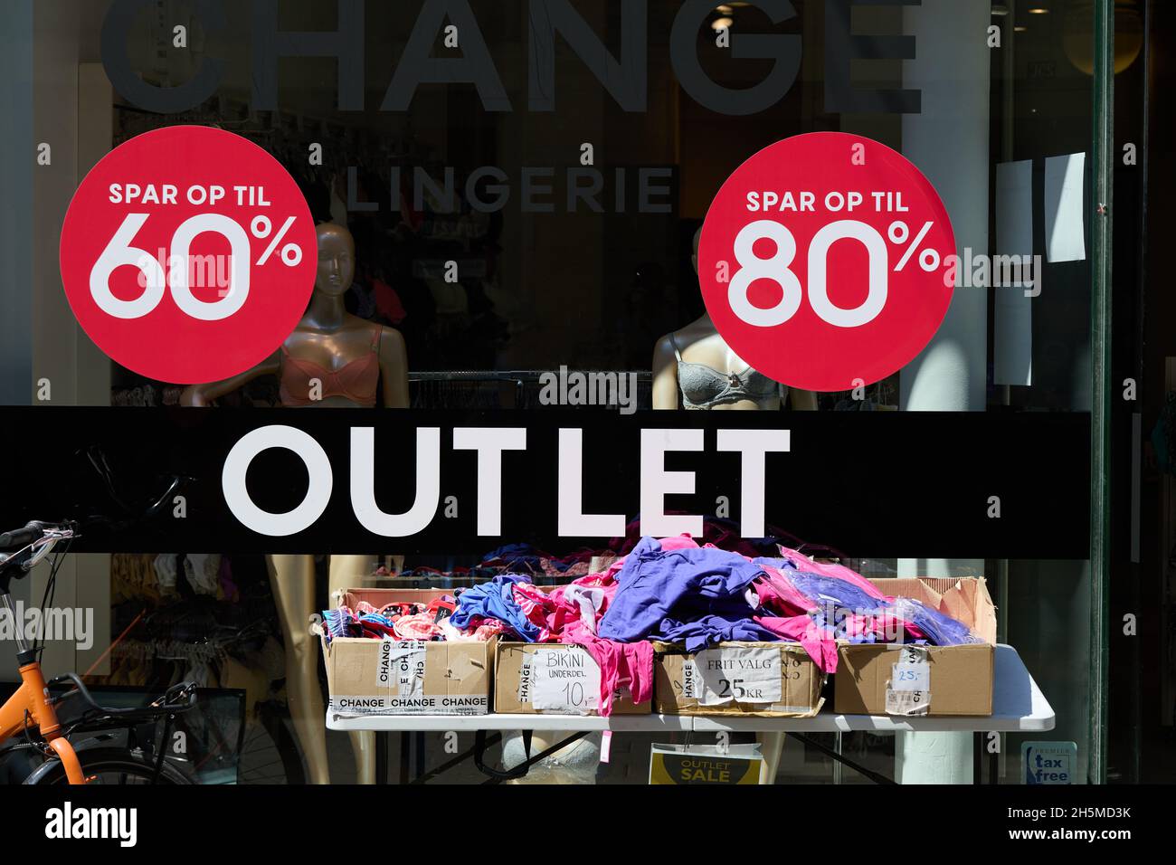 'Outlet', 'Spar op til 60%', 'Spar op til 80%' ('Salva fino al 60% / 80%'), insegne sul negozio di abbigliamento a prezzi scontati, Strøget, Copenhagen, Danimarca Foto Stock