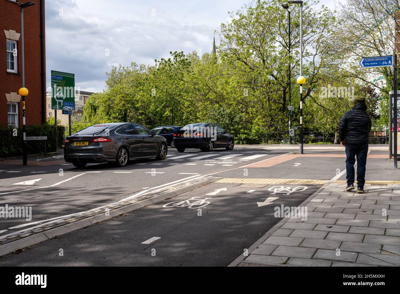 Una pista ciclabile protetta bidirezionale e l'attraversamento parallelo della zebra fanno parte del percorso ciclistico e pedonali di Filwood Greenway a Bristol. Foto Stock