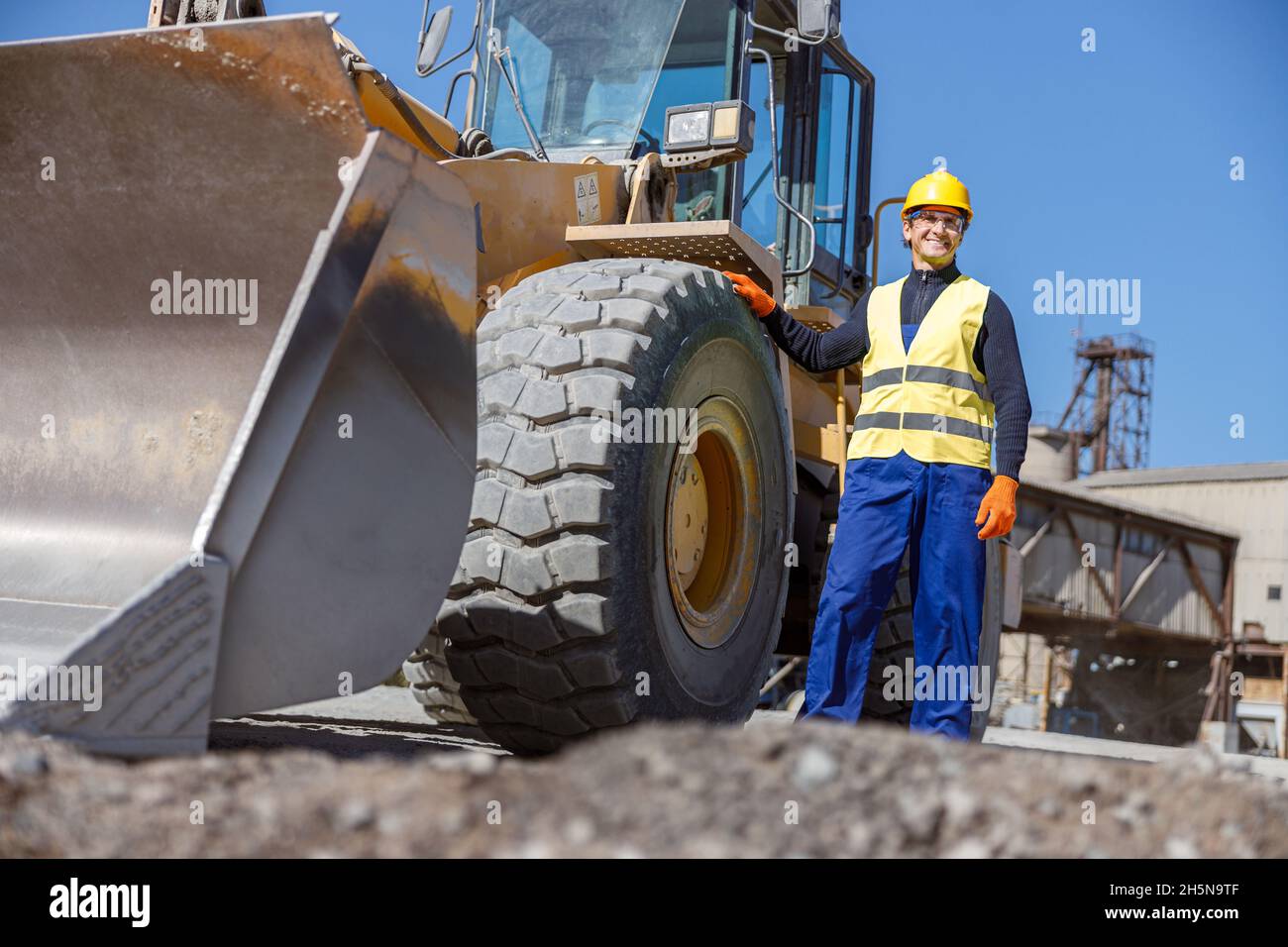 Allegro ingegnere maschile in piedi da veicolo industriale all'aperto Foto Stock
