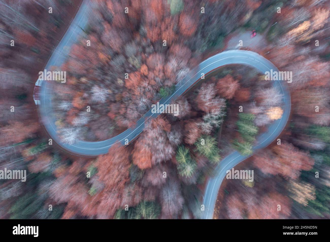 Vista aerea sfocata su una strada curva nella stagione autunnale. Foto Stock