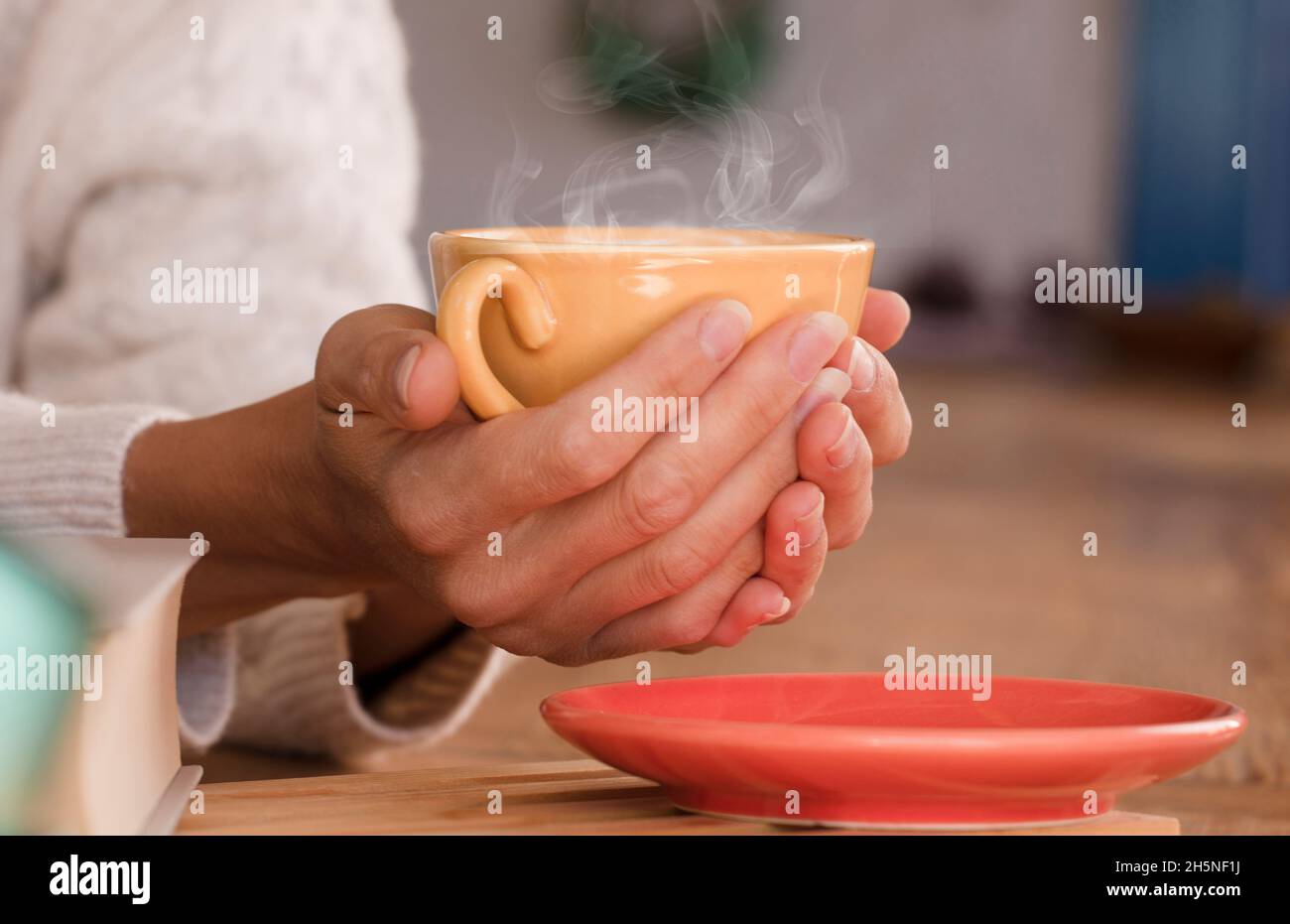 Scalda le mani con una tazza di caffè caldo.Focus sulla tazza Foto