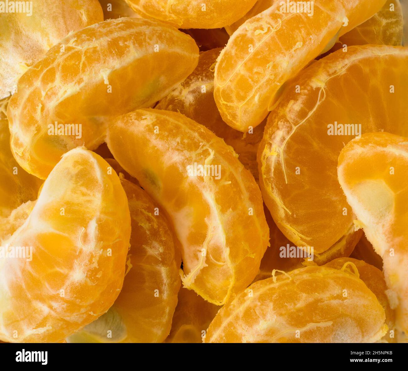 tangerini, fette o pezzi freschi di mandarino, fondo di agrumi, macro closeup Foto Stock