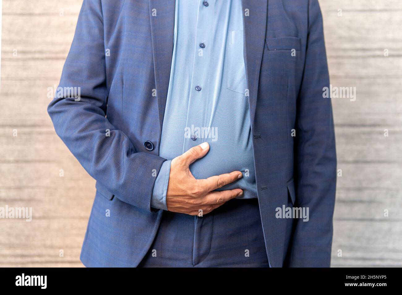 Indigestione dell'intestino da cibo di scarsa qualità. Concetto di diarrea. Uomo d'affari che ha stomachache a causa di mangiare cibo spazzatura. Foto Stock