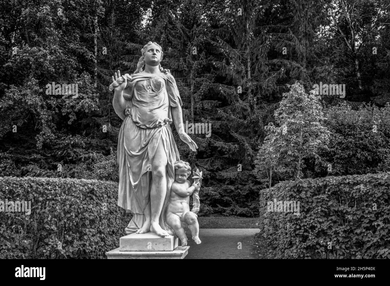 Antica statua di una donna con il suo bambino nel Parco inferiore di Peterhof. San Pietroburgo, Russia. Bianco e nero. Foto Stock