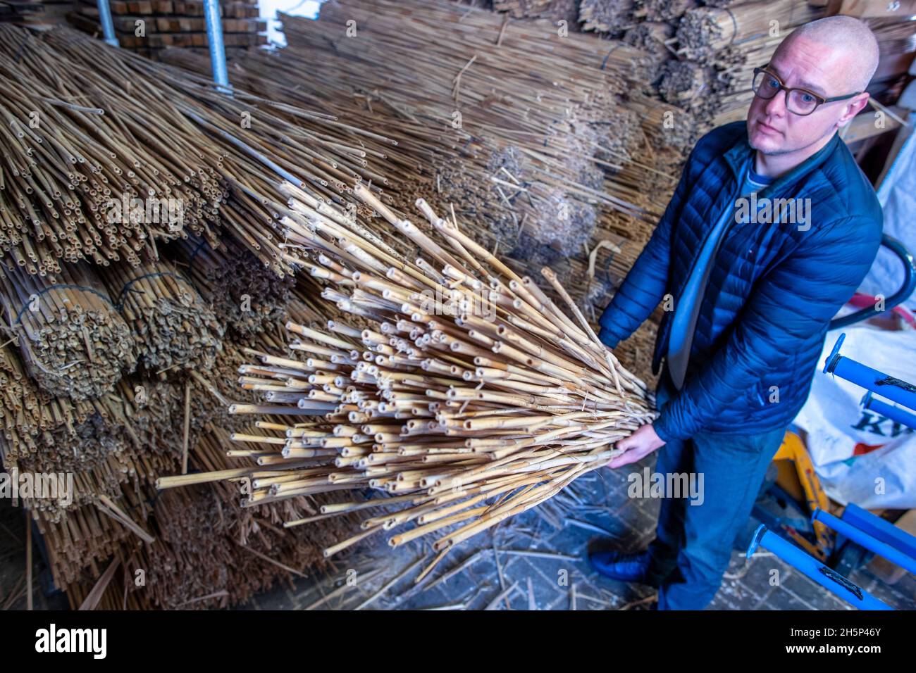 PRODUZIONE - 25 ottobre 2021, Meclemburgo-Pomerania occidentale, Kröpelin: Hannes Subklew, uno dei fondatori della start-up Rohalm, controlla la qualità della canna per la produzione di cannucce riutilizzabili. L'azienda produce le paillette lavabili in lavastoviglie da un anno. Dal divieto della plastica usa e getta, i ristoratori e gli organizzatori del partito cercano prodotti sostenibili alternativi. Nelle officine per disabili, la canna lunga più di due metri viene tagliata, pulita e levigata e vengono consegnate alla settimana diverse migliaia di cannucce da bere con diametri diversi. (a dpa Foto Stock