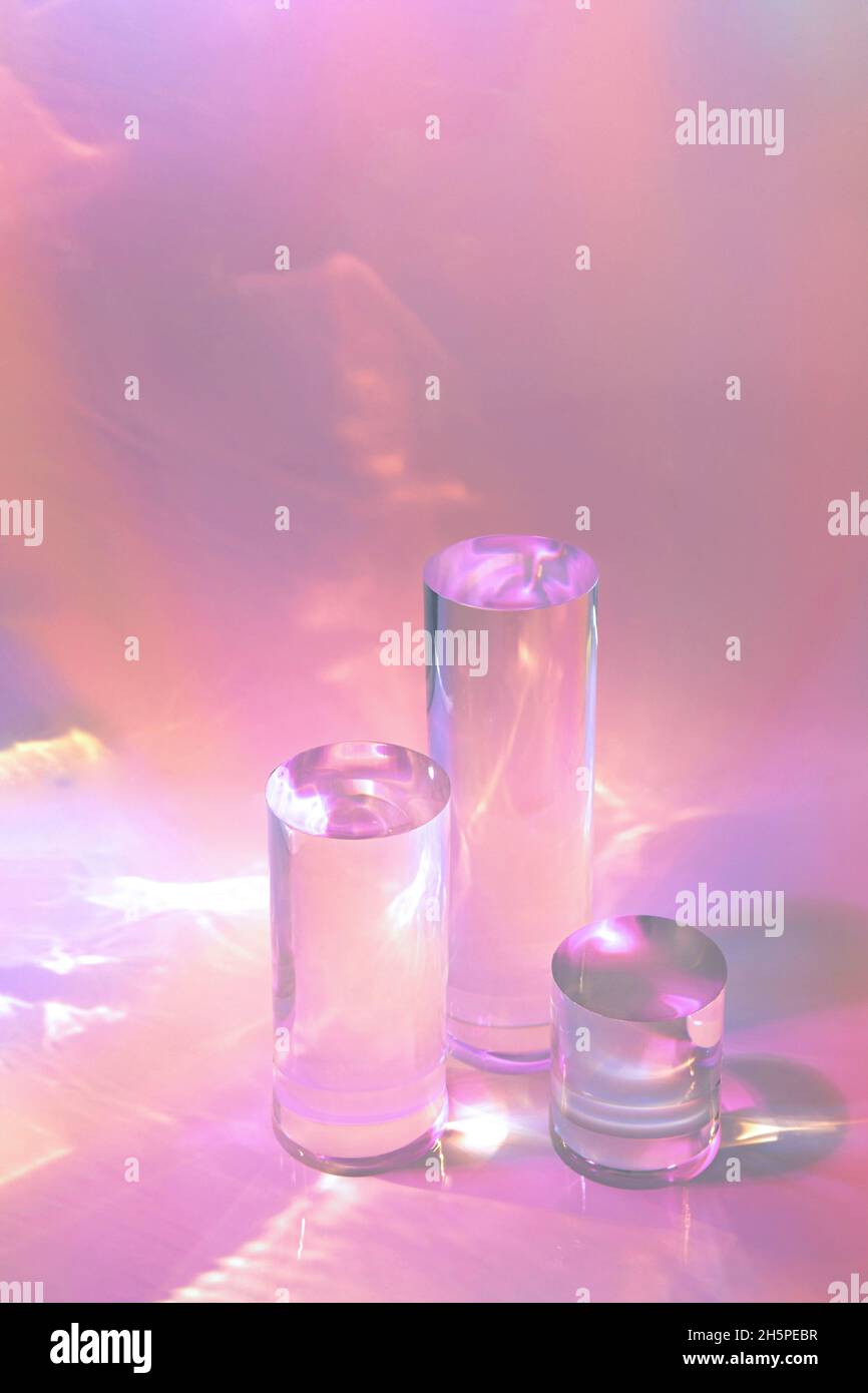 tre podi in vetro chiaro su sfondo rosa pastello Foto Stock
