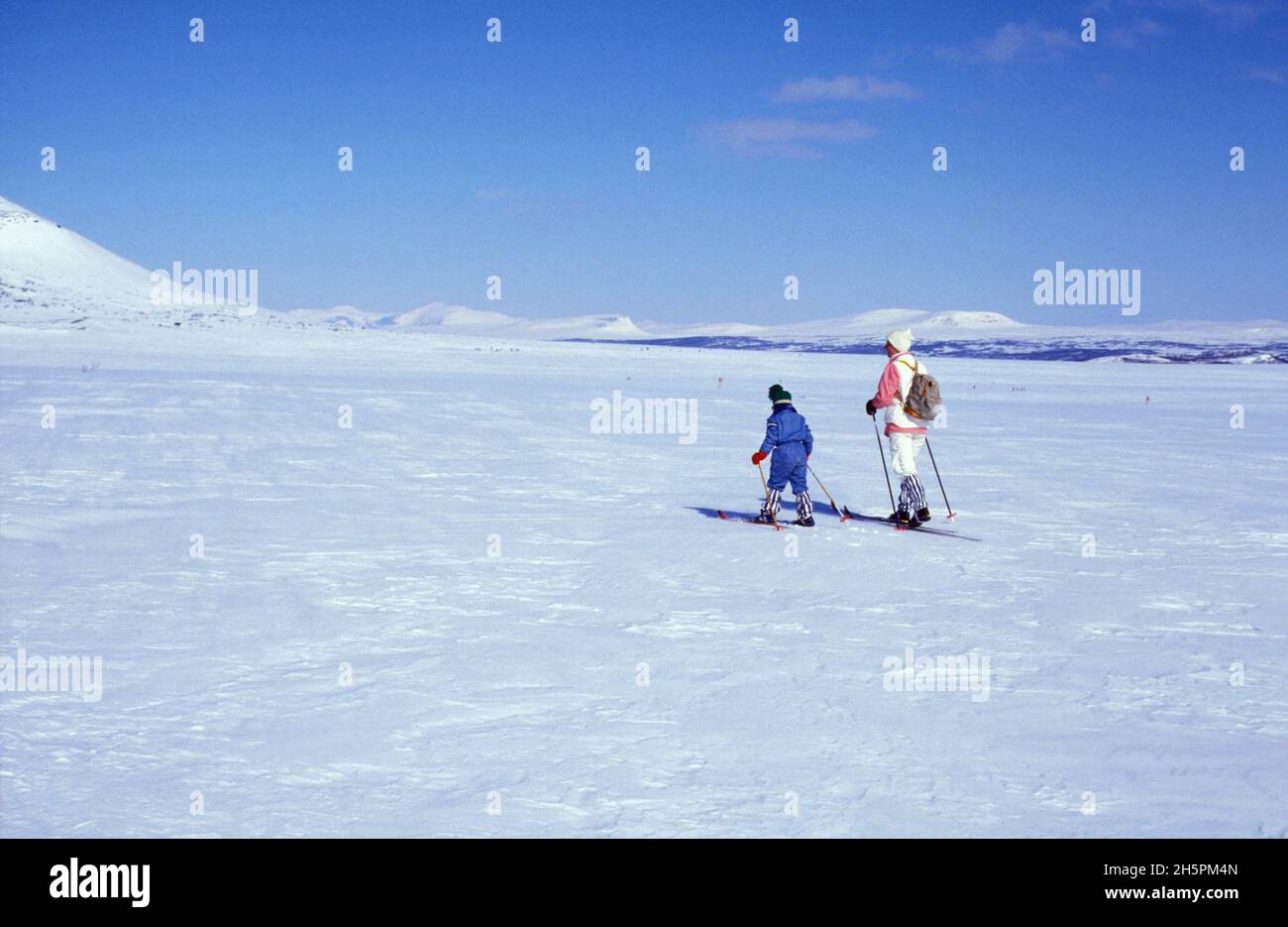 HÄRJEDALEN, SVEZIA NEL 1987, ANALOGICO. Paesaggio invernale in piena luce del sole in montagna. Persone non identificate. Uso editoriale. Foto Stock