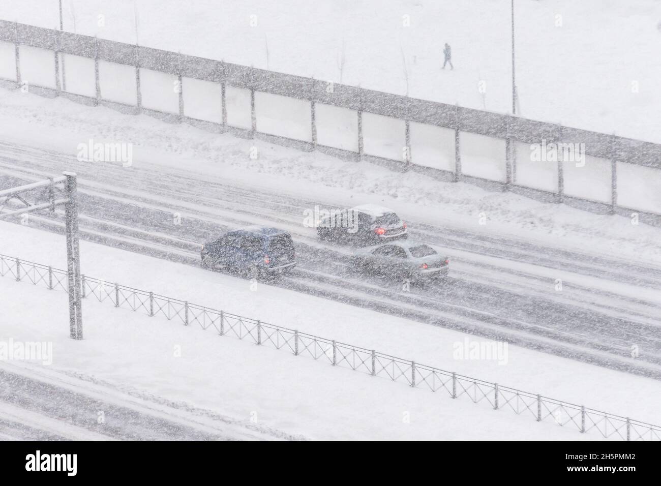 Le auto nella neve guidano in autostrada, con scarsa visibilità. Foto Stock