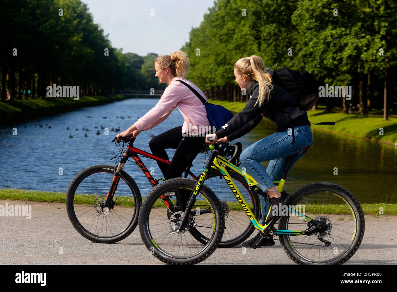 Due donne che cavalcano le biciclette insieme stile di vita sano Germania Europa in bicicletta Foto Stock