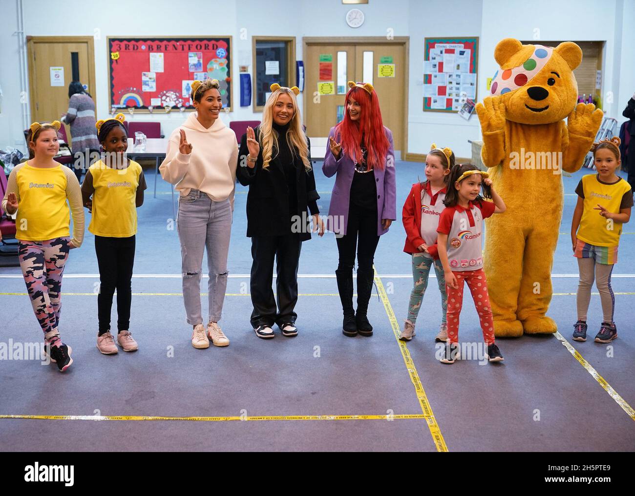 Rigorosamente venire ballerini professionisti Karen Hauer (centro a sinistra) e Dianne Buswell (centro a destra), con ex rigorosamente venire Dancing concorrente Saffron Barker e Pudsey Bear durante la loro visita ad un gruppo di Brownies e Girl Guides, presso la Brentford Free Church a Brentford, ovest di Londra. Data foto: Mercoledì 10 novembre 2021. Foto Stock