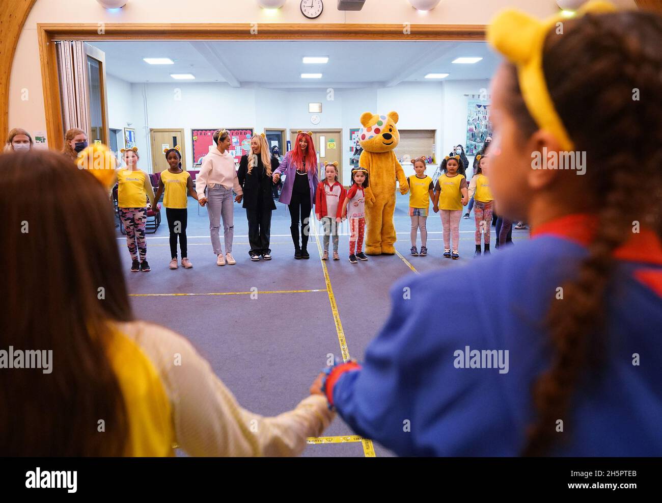 Rigorosamente venire ballerini professionisti Karen Hauer (centro a sinistra) e Dianne Buswell (centro a destra), con ex rigorosamente venire Dancing concorrente Saffron Barker e Pudsey Bear durante la loro visita ad un gruppo di Brownies e Girl Guides, presso la Brentford Free Church a Brentford, ovest di Londra. Data foto: Mercoledì 10 novembre 2021. Foto Stock