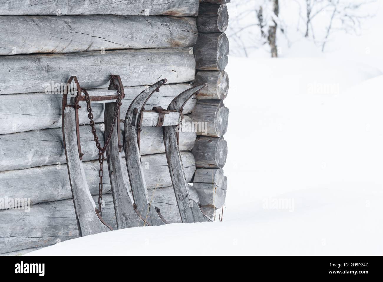 La vecchia slitta scivola contro il muro di legno Foto Stock