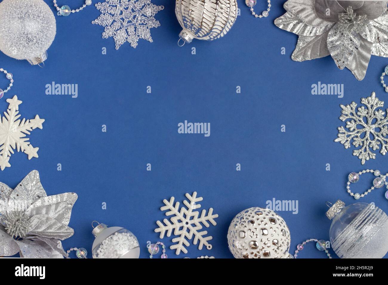 Cornice vacanza in argento e bianco lucido decorazioni natalizie su sfondo blu. Buon Natale, Natale e Capodanno. Vista dall'alto, Flat Lay, Co Foto Stock