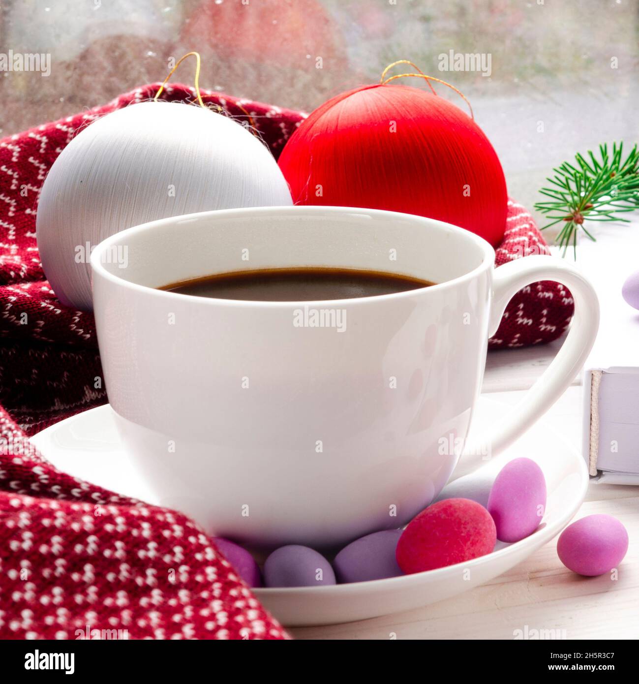 Tazza bianca di caffè del mattino su sfondo rosso caldo sciarpa. Casa accogliente concetto autunnale. Estetica blog stile di vita. Concetto di vita morta. Cappuccino o latte Foto Stock