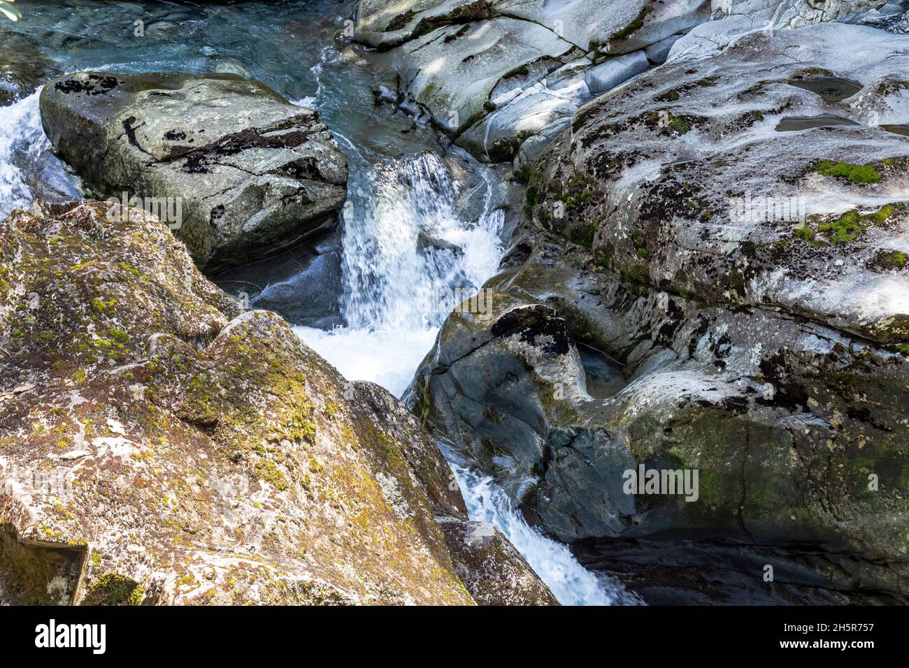 Parco Nazionale di Fiordland. Un flusso che scompare in un imbuto. Asm. Imbuto Ruscello tra le pietre. Nuova Zelanda. Foto Stock